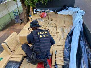 Policiais confere carga escondida em caminhão (Foto: DOF/Divulgação)