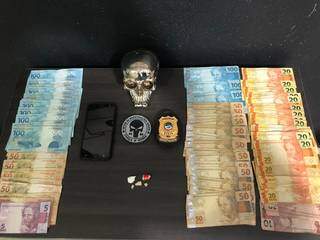 Dinheiro, celular e porções de droga apreendidos no endereço. (Foto: Polícia Civil) 