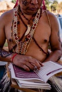 Indígena terena lendo uma das obras. (Foto: Luciano Justiniano)