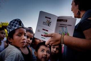 Denise mostrando os livros às crianças. (Foto: Luciano Justiniano)