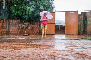 Erlina contando dos prejuízos que a chuva já lhe trouxe. (Foto: Henrique Kawaminami)