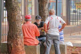 Aposentados levaram jogo para bancos na calçada da 14, para fora da Praça. (Foto: Silas Lima)