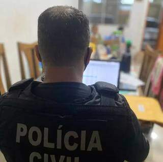 Policial fazendo buscas em computador de um dos presos. (Foto: Divulgação/Polícia Civil)