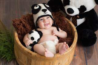 Este nenê sorri pra foto segurando um panda e vestindo uma touca combinando que as irmãs mesmas produziram (Foto: Isabelle Tanji)