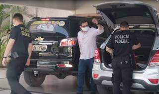 Marcelo Iunes (de camisa e máscara) deixa sua casa enquanto policiais ainda recolhiam documentos (Foto: Reprodução de vídeos) 