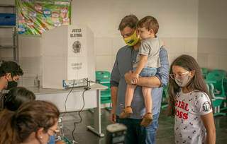 Com filho no colo, Vinicius se apresenta para mesários (Foto: Assessoria do candidato)