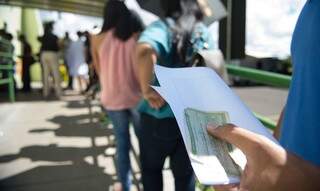 Eleitor na fila de votação, com título na mão. (Foto: Marcelo Camargo / Agência Brasil) 