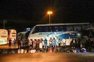 Passageiros enfileirados ao lado do ônibus durante a revista policial. (Foto: Paulo Francis)