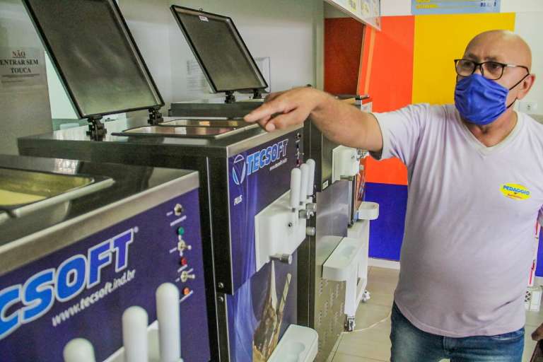 Manoel mostrando sorvete derretido dentro das máquinas. (Foto: Silas Lima)