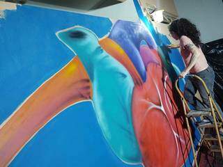 Natacha Figueiredo realizando pintura em parede. (Foto: Arquivo Pessoal)