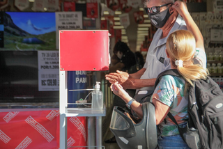 Mulher ajeita máscara de homem antes de entrar na loja (Foto: Marcos Maluf) 