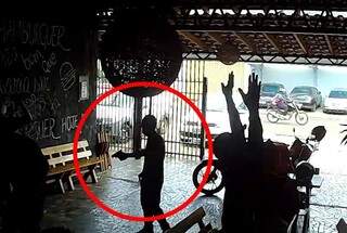 Assaltante com arma em uma das mãos rendendo funcionários e clientes de restaurante (Foto: Reprodução)