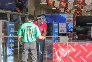 Funcionários com máscaras se prepando para abrir a loja (Foto: Marcos Maluf) 