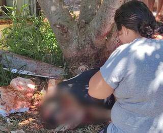 Mulher ajoelhada ao lado do corpo de Joari; ele foi executado hoje em Ponta Porã (Foto: Direto das Ruas)