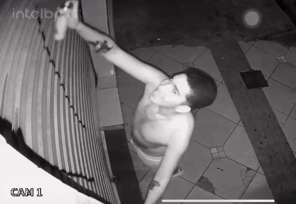 Sorrindo, sem notar c&acirc;mera, v&acirc;ndalos s&atilde;o flagrados pichando loja 
