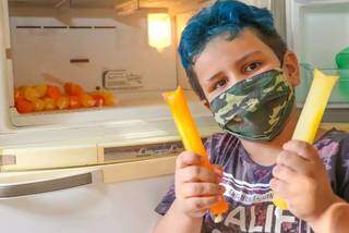 Aqui, menino segura dois geladinhos, um de laranja, outro de salada de fruta (Foto: Paulo Francis)