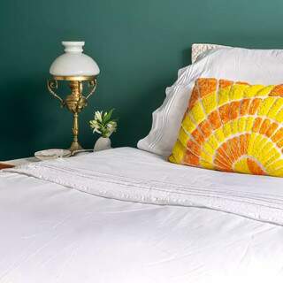 Assim como a tinta de parede, almofadas dão vida numa cama toda branca (Foto: Janaina Lott)