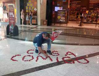 Luciano arrumando meticulosamente a mensagem escrita com rosas (Foto: Arquivo Pessoal)