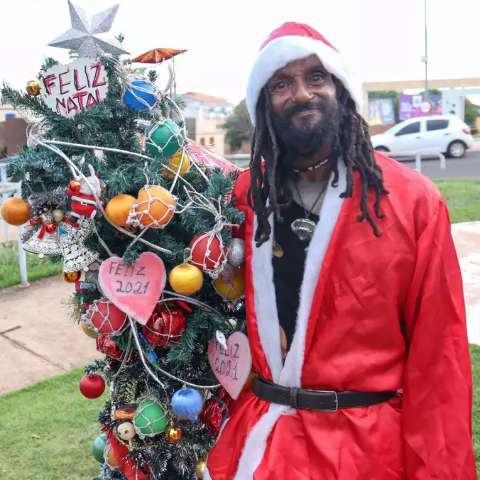 Mesmo com pouco, Camu se veste de Papai Noel e enfeita árvore na rua