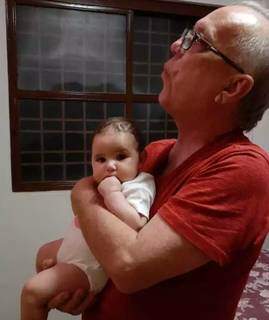 Avô, Guilherme vivia assoviando e como passarinho voou para o céu na noite de ontem; no colo está com a neta Marina (Foto: Arquivo Pessoal)