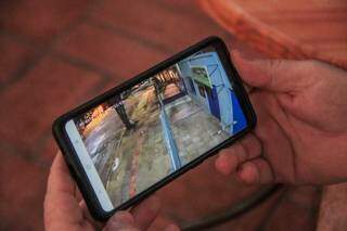 Morador mostra no celular imagens da câmera que vigia ruas. Ele pensa em desistir do Amambaí após 35 anos. (Foto: Marcos Maluf)