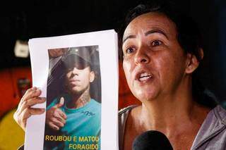 Mãe de Hugo com cartaz com a foto de Maikon nas mãos. (Foto: Henrique Kawaminami)