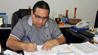 Prefeito de Corumbá, Marcelo Iunes, assina documento no gabinete (Foto: Divulgação)