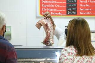Consumidores observam peça de carne em açougue de Campo Grande (Foto: Kísie Ainoã)