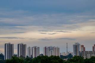 No horizonte, prédios contranstam com céu entre nuvens no amanhecer no Centro de Campo Grande. (Foto: Henrique Kawaminami)