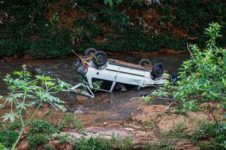 Veículo Fiat Uno caiu no córrego e parou com as rodas para cima. (Foto: Henrique Kawaminami)