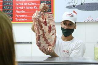 Funcionária de açougue mostra peça de carne para consumidora (Foto: Kísie Ainoã/Arquivo)