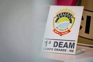 Placa identificando a Deam, unidade da Polícia Civil dedicada à investigação de violência contra a mulher. (Foto: Arquivo Campo Grande News)