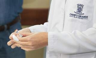 Frasco com 10 doses da CoronaVac nas mãos de profissional de saúde na Capital. (Foto: Denilson Secreta/Prefeitura de Campo Grande)
