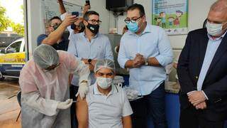 Valdeci (centro) é enfermeiro e foi o primeiro a receber a vacina contra a covid em Dourados. (Foto: Helio de Freitas)