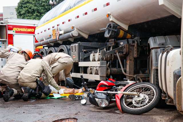 Motociclista para sob carreta e roda passa por cima de perna