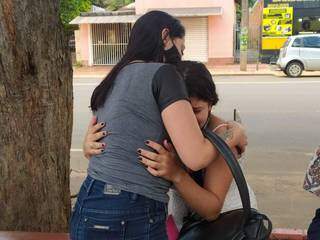 Eula (branco) é consolada por amiga; ela ficou sabendo da morte do marido pelas redes sociais (Foto: Liniker Ribeiro)