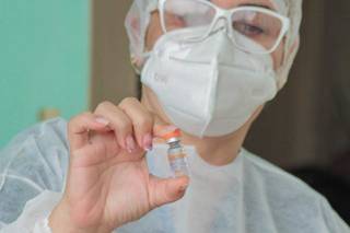 Profissional de saúde segura dose de vacina Coronavac, em Campo Grande (Foto: Marcos Maluf/Arquivo)