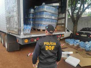 Policial observa caminhão que levava maconha sob garrafas de água mineral (Foto: Adilson Domingos)