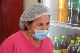 De máscara e touca, Aparecida da Silva trabalha vendendo salgados e bebidas. (Foto: Marcos Maluf)