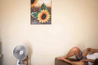 Na parede da sala, a vítima ainda expõe quadro de girassol, a flor preferida, mas agora, a leva direto à lembrança do abuso (Foto: Henrique Kawaminami)