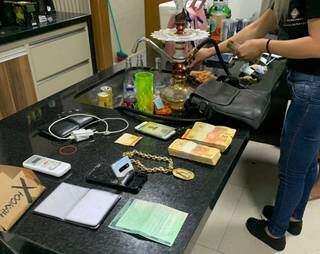 Corrente de ouro, maços de dinheiro e documentos apreendidos em operação hoje na fronteira (Foto: Direto das Ruas)