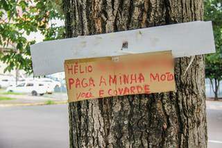 Recado escrito à mão em papelão cobra dívida de moto (Foto: Silas Lima)