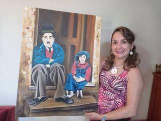 Daniel com retrato de Charlie Chaplin pintado por ela (Foto: Arquivo Pessoal)