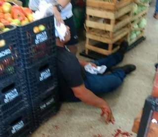 Vítima ferida na cabeça sentado no chão do mercado. (Foto: Diário Corumbaense)