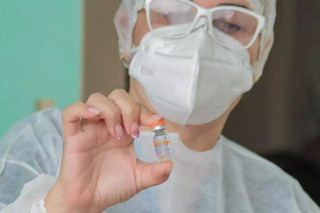 Profissional de saúde segura dose da vacina Coronavac, em Campo Grande (Foto: Marcos Maluf/Arquivo)
