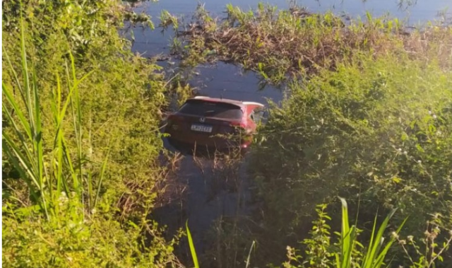 Carro com registro de roubo no RJ cai em &aacute;rea alagada e motorista foge 