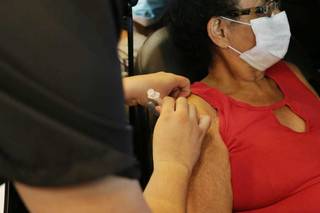 Profissional do polo de vacinação no Parque Ayrton Senna aplica dose de vacina contra a covid-19 (Foto: Paulo Francis)