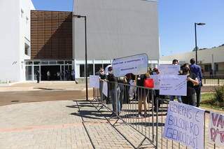 Manifestantes com cartazes em frente à unidade inaugurada hoje (Foto: Helio de Freitas)
