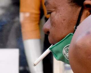 &#34;Proteção&#34;: registro de uma mulher com a máscara abaixada na pausa de furmar um cigarrinho (Foto: Roberto Higa)