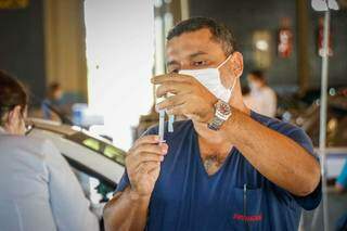 Enfermeiro prepara dose de vacina para aplicar em idoso (Foto: Henrique Kawaminami)